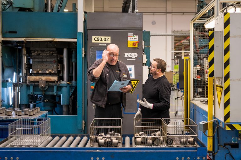 Reportage en industrie. Un salarié et un manager d'une entreprise industrielle, échangeant sur le poste de travail.