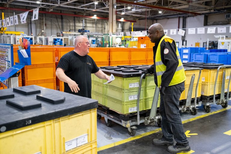 Échanges entre deux salariés (production, logistique) d'une entreprise industrielle