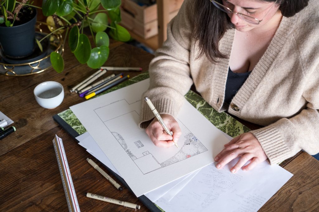 Gabrielle Brunet, paysagiste en éco-jardin, dessinant au crayon